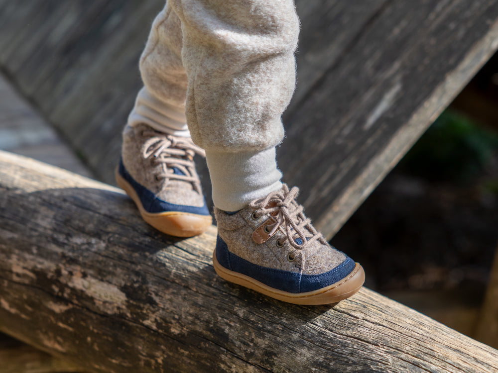 Ab wann Lauflernschuhe: Kind läuft mit Lauflernschuhen auf Spielplatz.