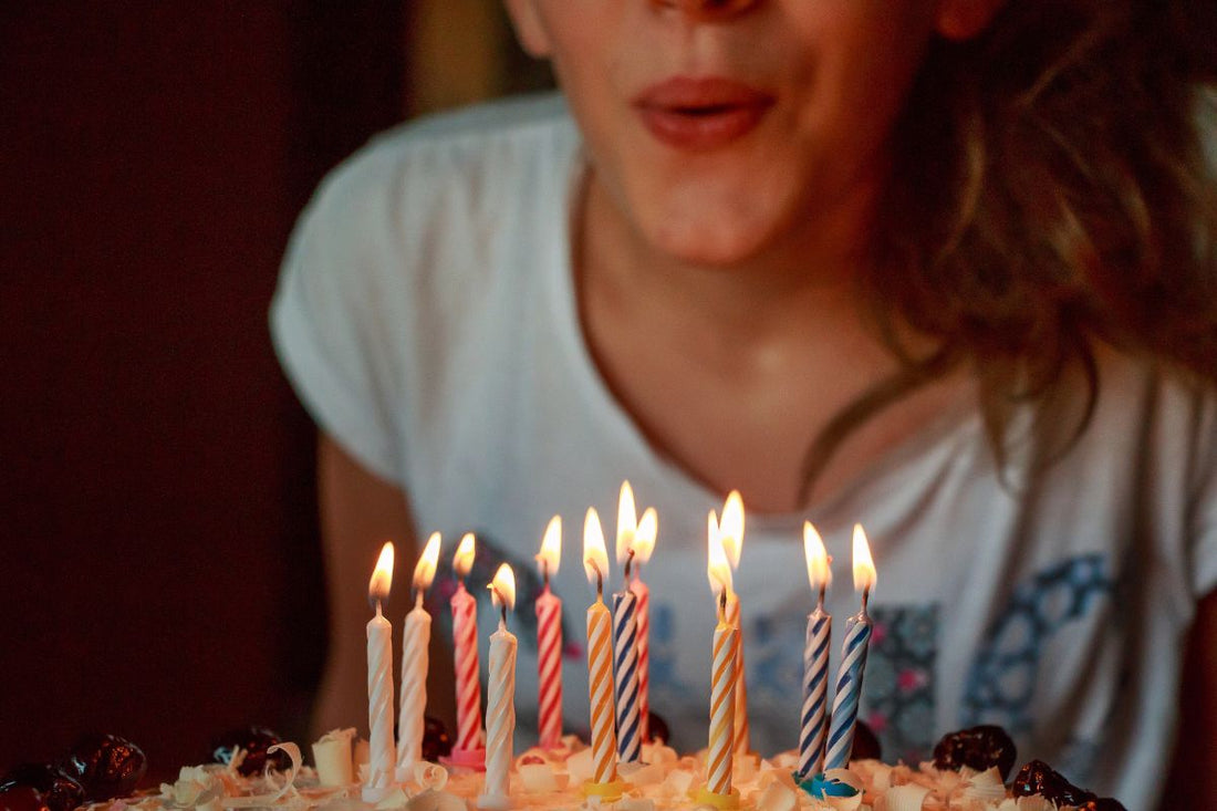Kindergeburtstag Ideen 11 bis 12 Jahre: Kind pustet Geburtstagskerzen aus.