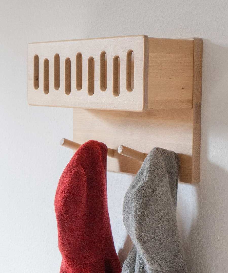 Flexible Montagehöhe*Die Garderobe kann flexibel auf kindgerechter Höhe montiert werden, sodass sich dein Kind selbst an- und ausziehen kann.|Nahaufnahme Garderobe mit praktischem Ablagefach.
