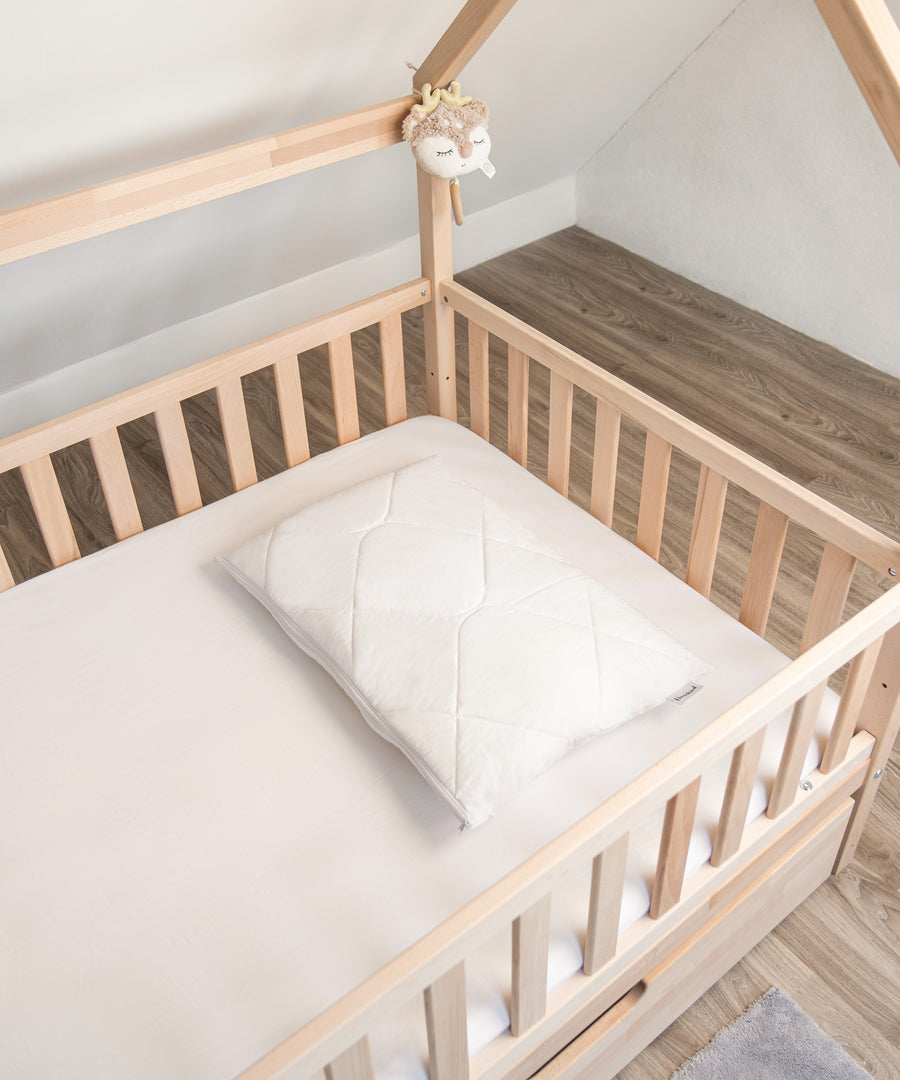 Hautsympathisch*Besonders geeignet für empfindliche Kinderhaut: Das höhenverstellbare Kissen ist OEKO-TEX STANDARD 100 zertifiziert.|Höhenverstellbares Kissen liegt im Bett.