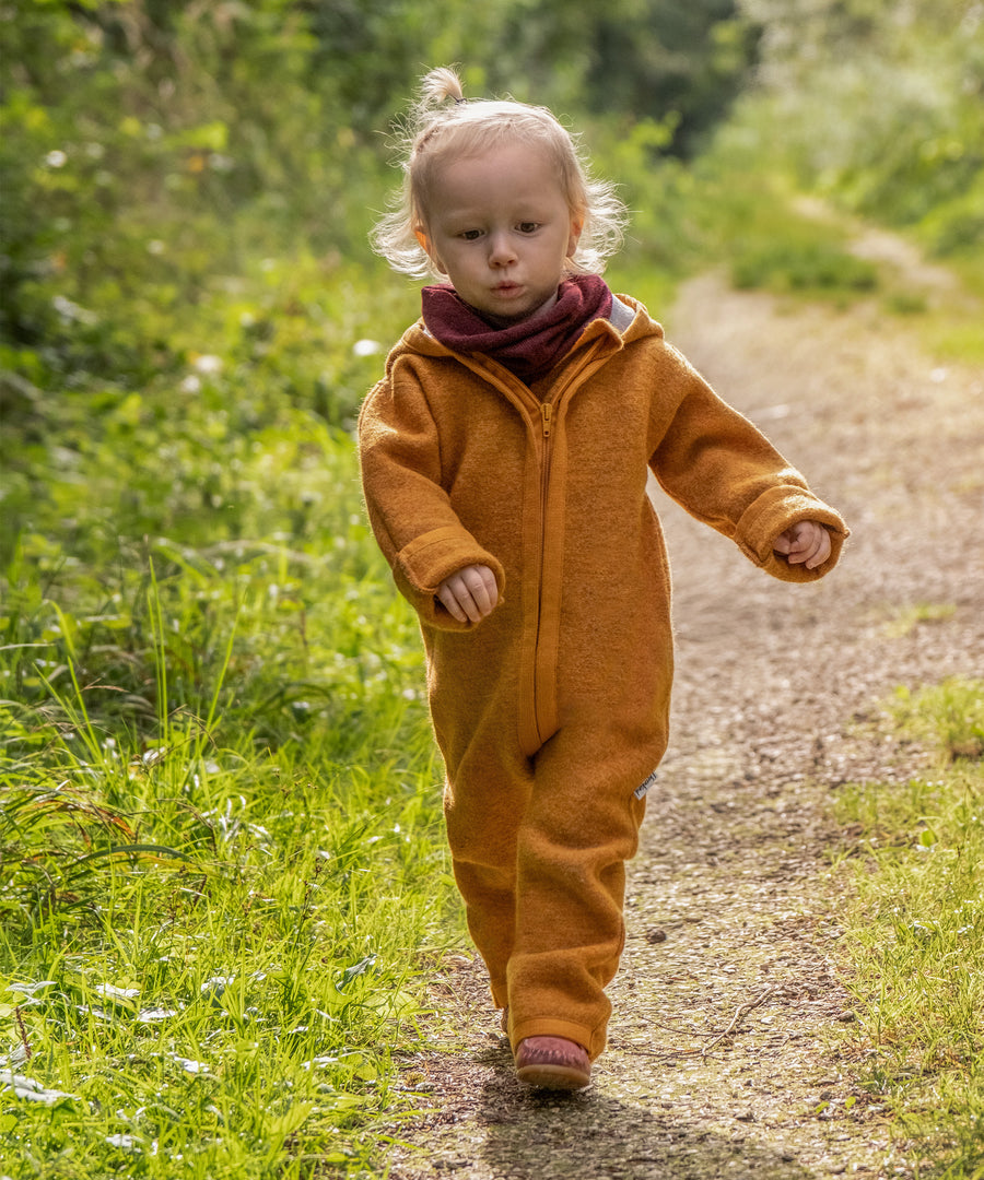 Made in Germany*Der hochwertige Schlauchschal im zeitlosen Design wird in Deutschland produziert.|Mädchen mit Walkoverall und Schlauchschal auf Waldweg.