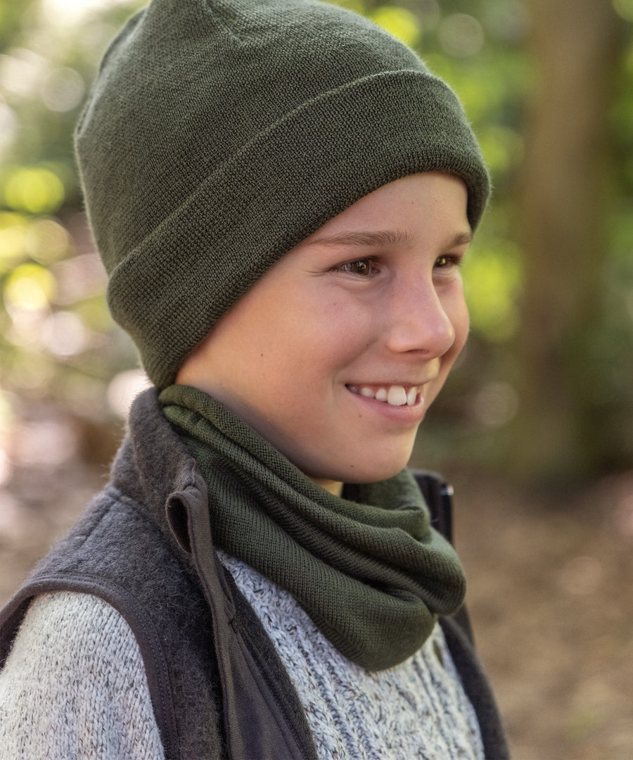 Junge mit Schlauchschal und Strickmütze in Oliv.