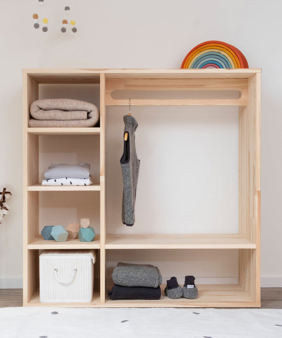 Schönes Kiefernholz*Unser Kleiderschrank wird aus hochwertigem Kiefernholz aus nachhaltiger Forstwirtschaft gefertigt.|Montessori Kleiderschrank Kiefer mit Kleidung und Accessoires befüllt.