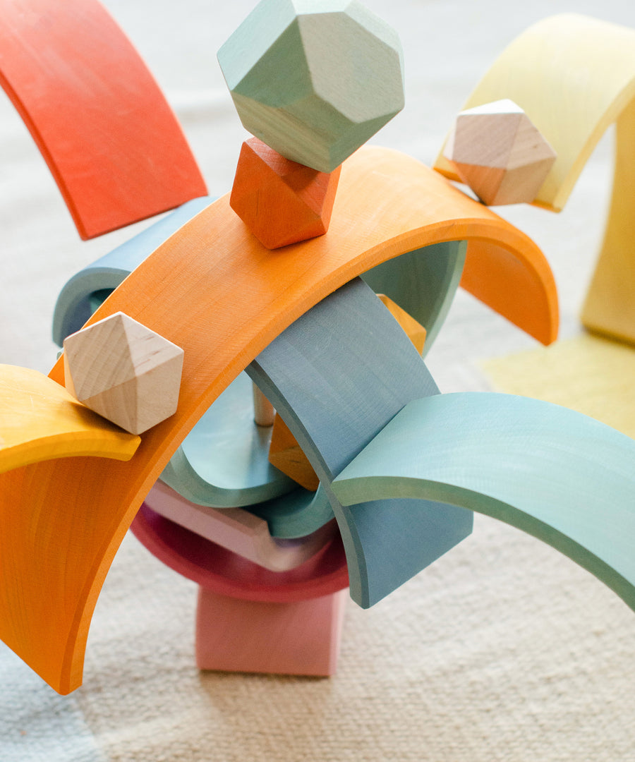 Turm mit Regenbogen-Elementen und Balanciersteinen, Regenbogen ist von Montessori inspiriert.