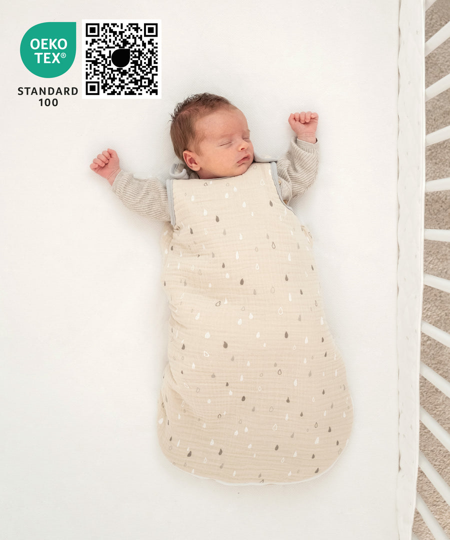 Baby schläft im Musselin Babyschlafsack.