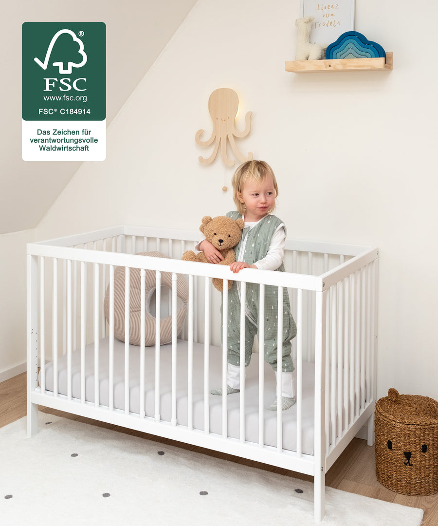 Robust & Kindgerecht*Das Bett bietet deinem Kind Geborgenheit beim
Spielen und Schlafen.|Kind steht im Babybett.