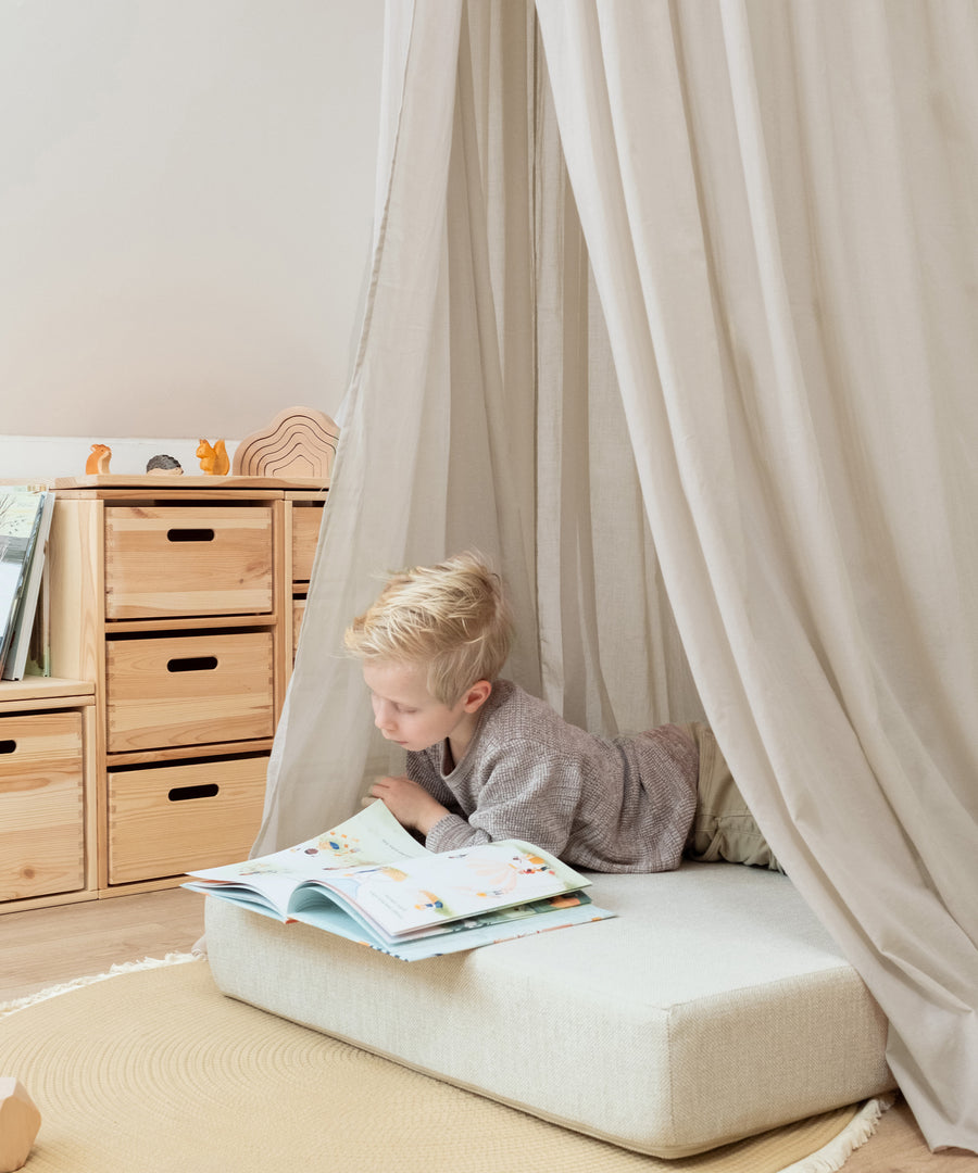 Kinder-Leseecke unter beigem Baldachin.