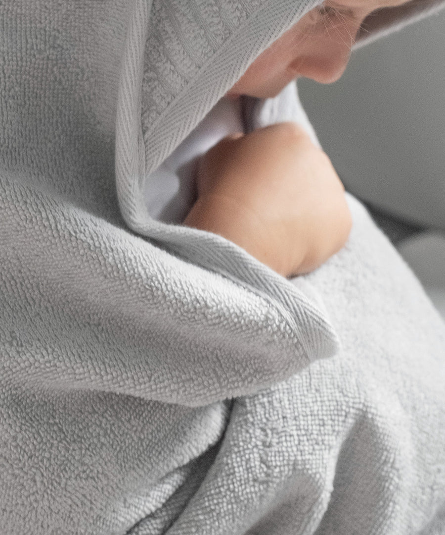 Perfekt zum Einkuscheln*In der Größe 100 × 100 cm ist das Kapuzenhandtuch besonders komfortabel, ob nach dem Baden zuhause oder unterwegs.| Kind ist nach dem Baden in ein Kapuzenhandtuch eingewickelt.
