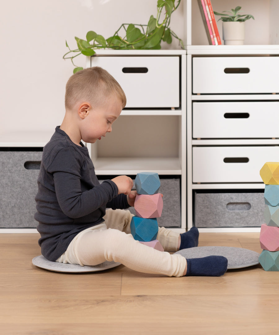 Kleine Sitzinsel zum Spielen*Einfach dorthin legen, wo gerade gespielt wird – und schon entsteht ein bequemer Platz zum Bauen und Entdecken.|Kind nutzt das weiche Sitzkissen auf dem Boden als bequemen Platz zum Spielen.