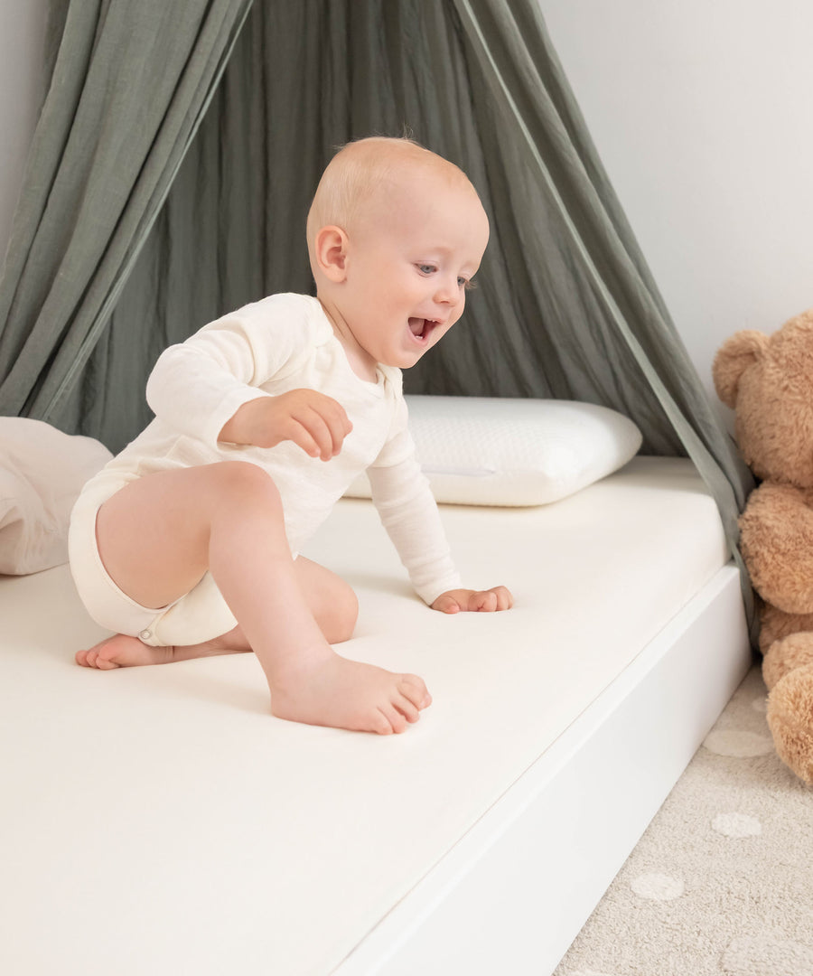Baby in Action auf Bodenbett.