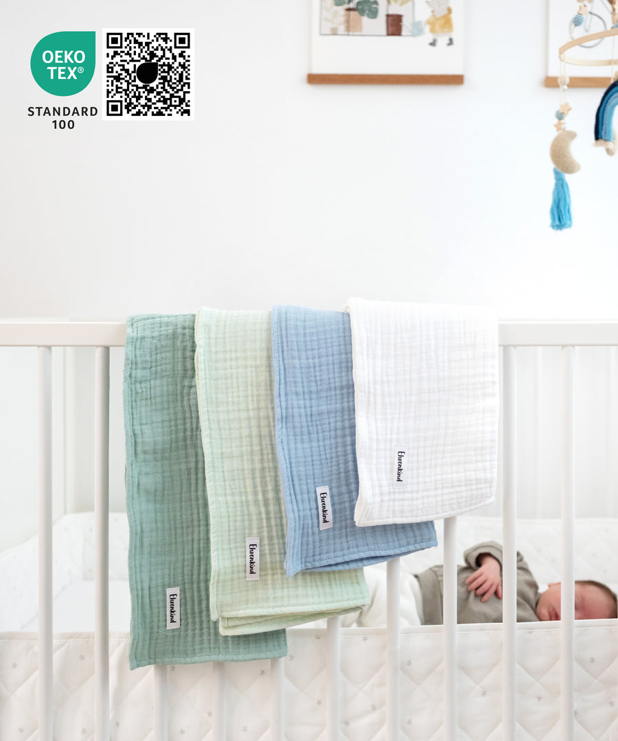 Mulltücher-Set Blau hängt über Gitterbett.