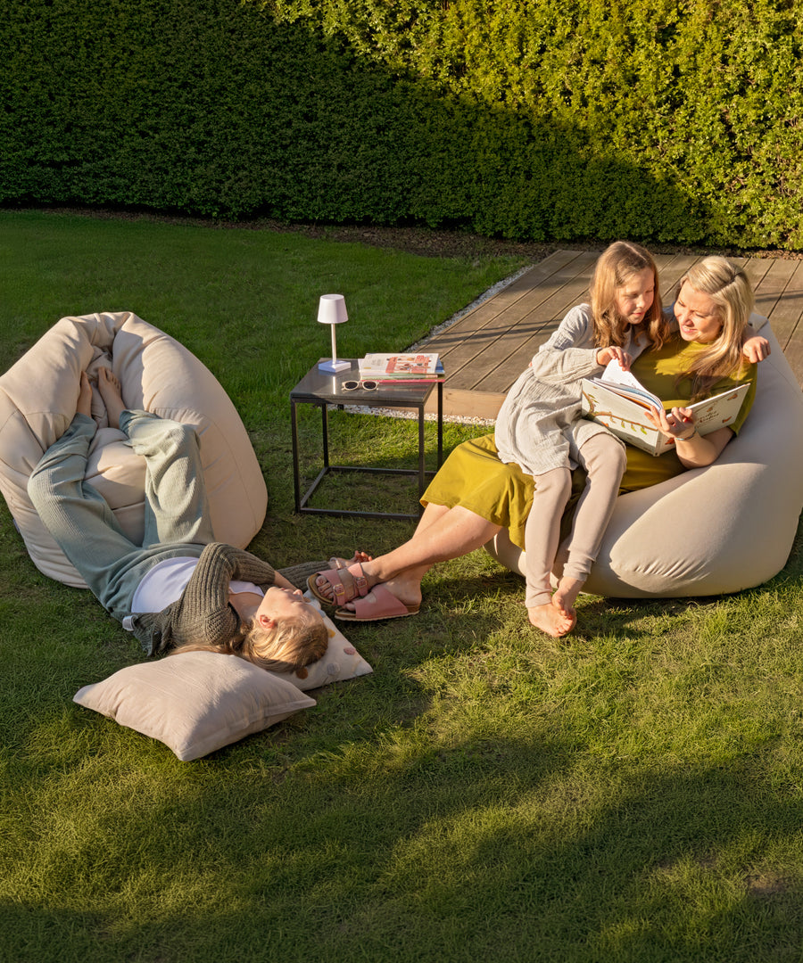 Ein Platz, der euch zusammenbringt*Der XXL-Sitzsack schafft Raum, an dem Familie und Freunde zusammenkommen - zum Lesen, Reden oder einfach Beisammensein.|Familie entspannt gemeinsam auf einem großen Sitzsack XXL.