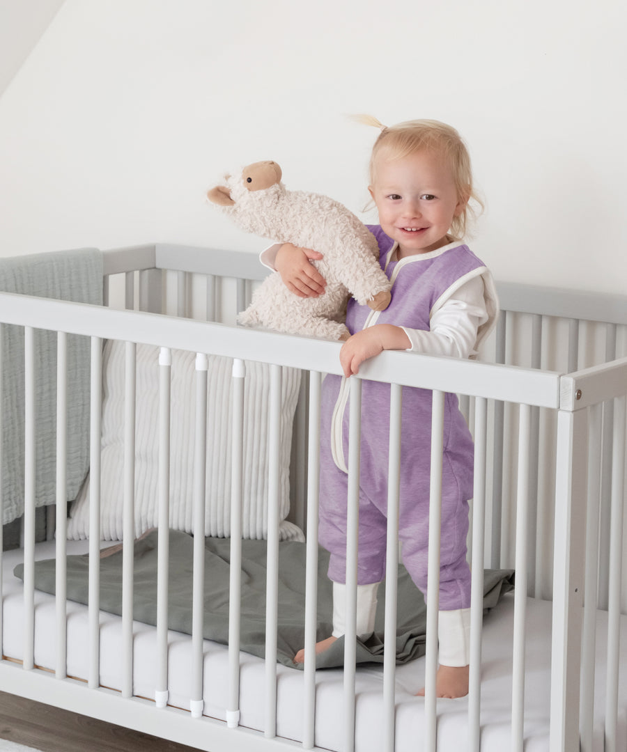 100% natürliche Materialien*Der Schlafsack aus Bio-Baumwolle mit reinster Schurwollfüllung bietet deinem Baby Geborgenheit und ein optimales Schlafklima.| Kind trägt den Fliederfarbenen Schlafsack