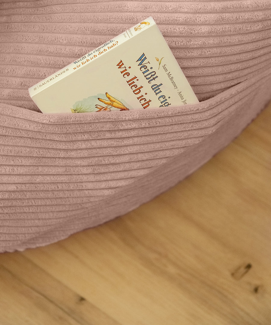 Ein Buch liegt in der Seitentasche des Sitzsacks.