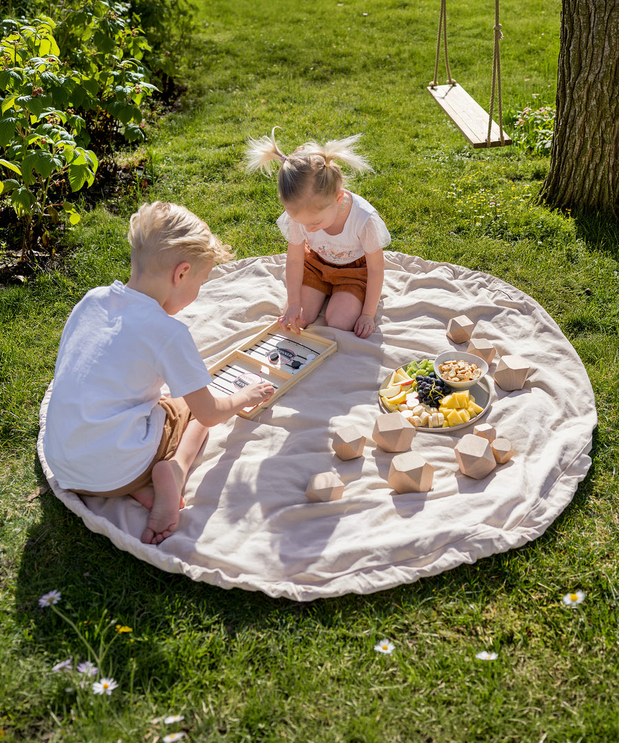 Kinder nutzen den Spielzeugsack als Unterlage